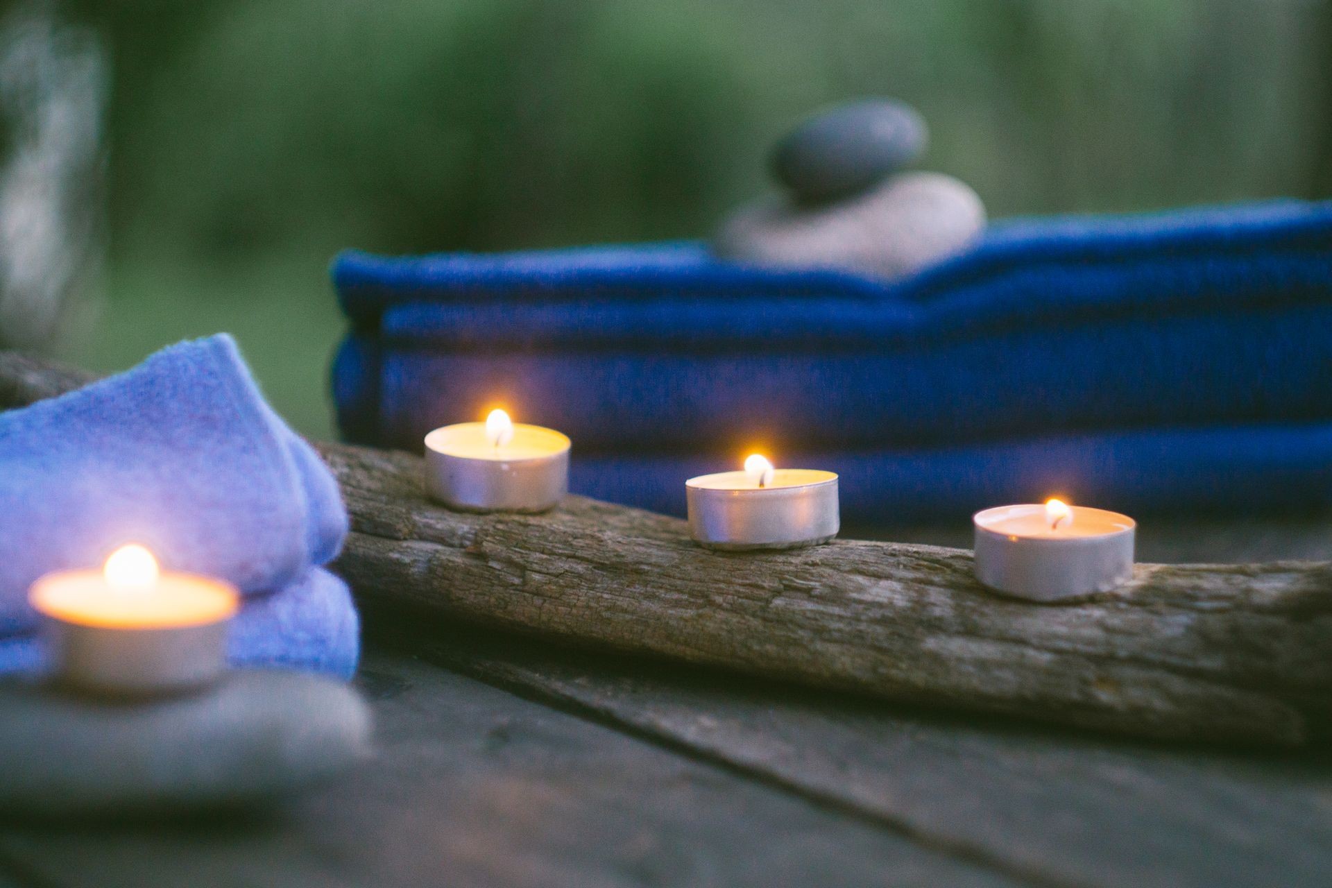 Relax spa concept with burning candles, stones, towels and aroma oil. Old wooden background